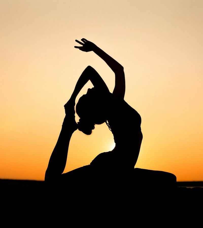 Silhouette of a person in a yoga pose against a beautiful sunset.